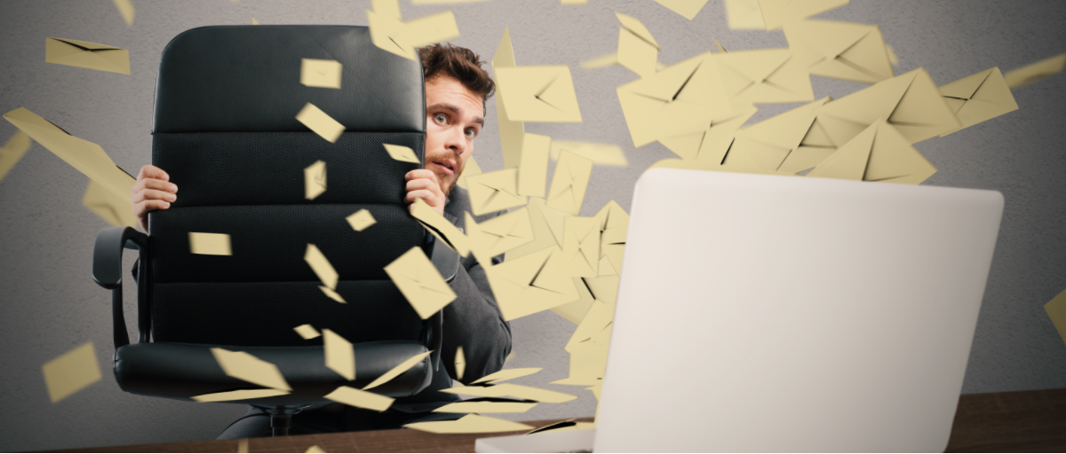 koltuk arkasında, bilgisayardan fırlayan e-postalardan saklanan bir adam